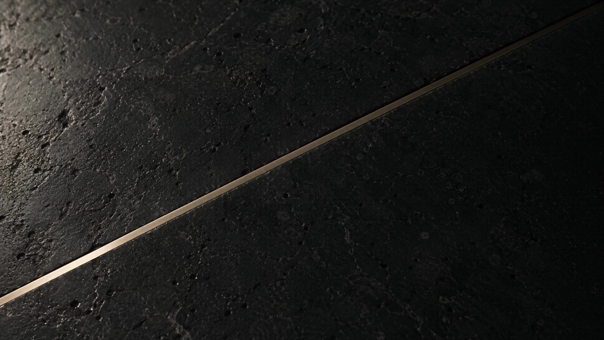 Honed limestone meeting a narrow satin champagne seam